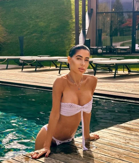 Virginia Olivero, modella OnlyFans, foto in piscina con un sexy bikini bianco.