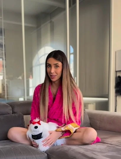 Michelle Comi, modella di OnlyFans, foto con un accappatoio rosa.