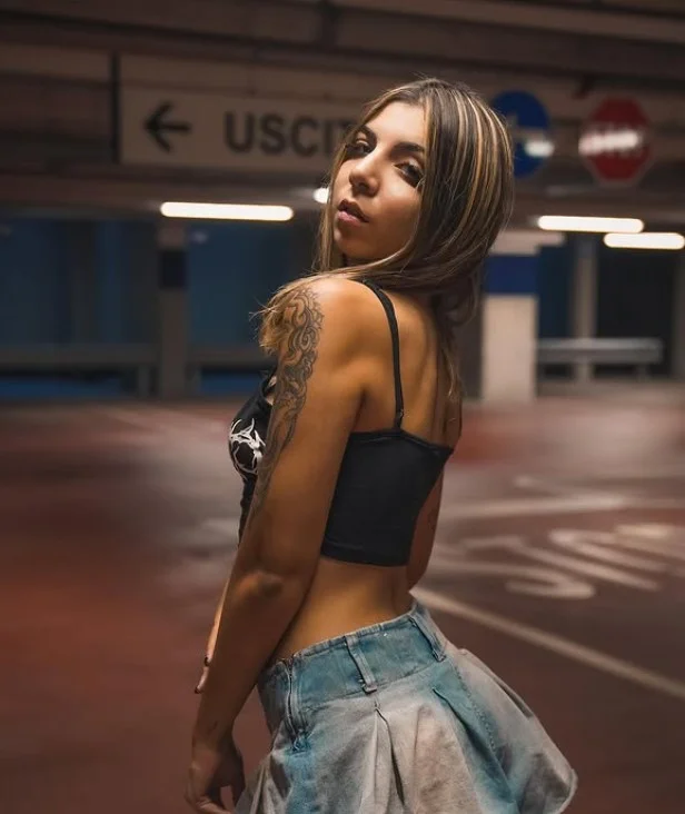 Chiara Alexia @chiaraalexia Foto di modella OnlyFans in piedi con indosso un top nero