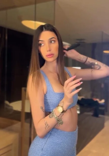 Michelle Comi, modella di OnlyFans, foto con un top blu.