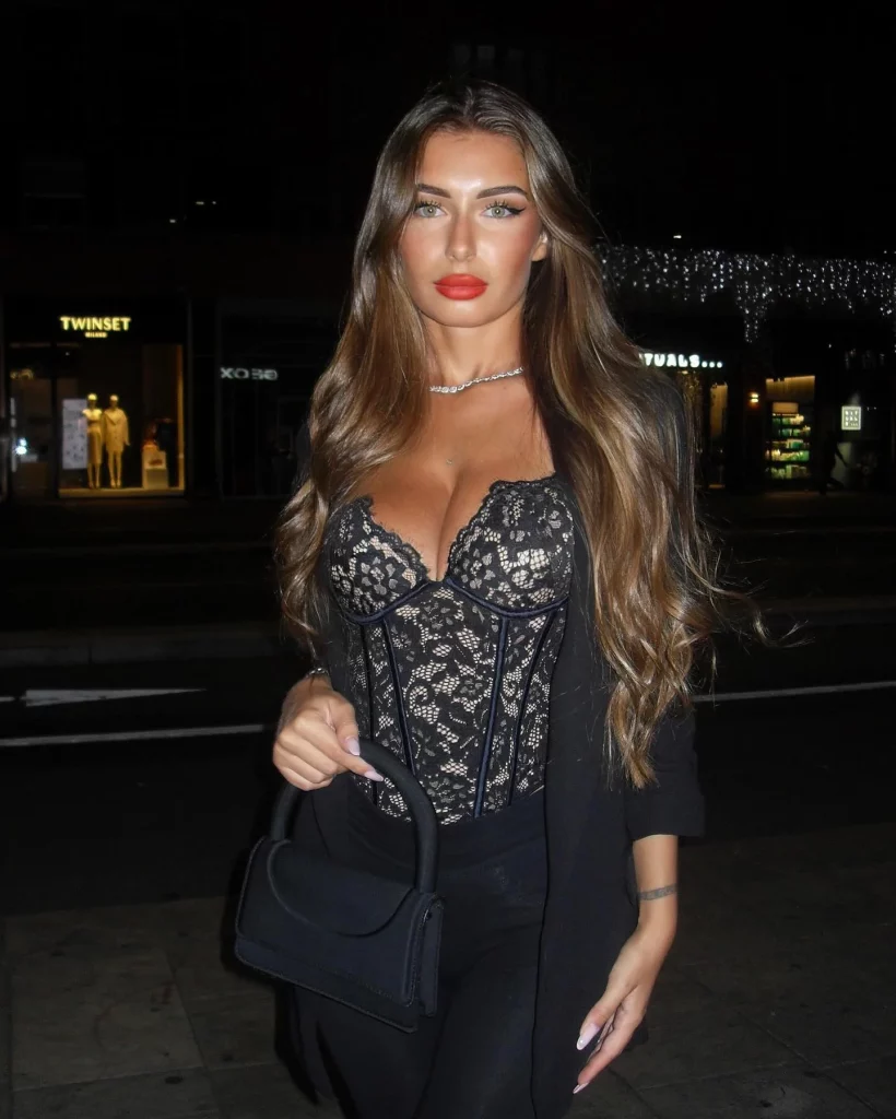 Elisa Esposito @eli.esposito foto della modella di OnlyFans in piedi con una borsa e indossando un top nero