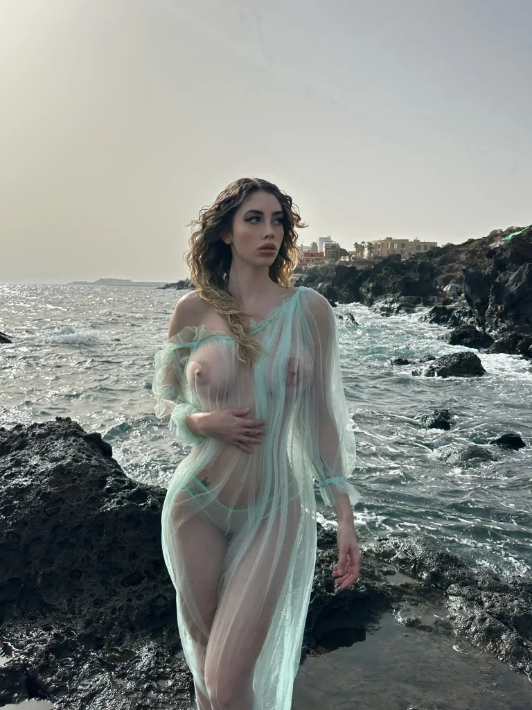 Eva Menta @evamenta foto del modello OnlyFans sulla spiaggia in abiti trasparenti che espongono il suo corpo sexy.