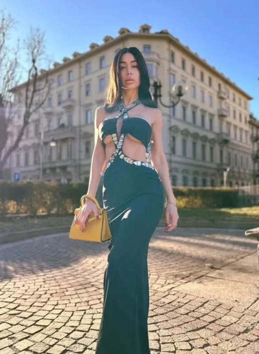 Virginia Olivero, modella OnlyFans, in piedi con un elegante vestito nero.