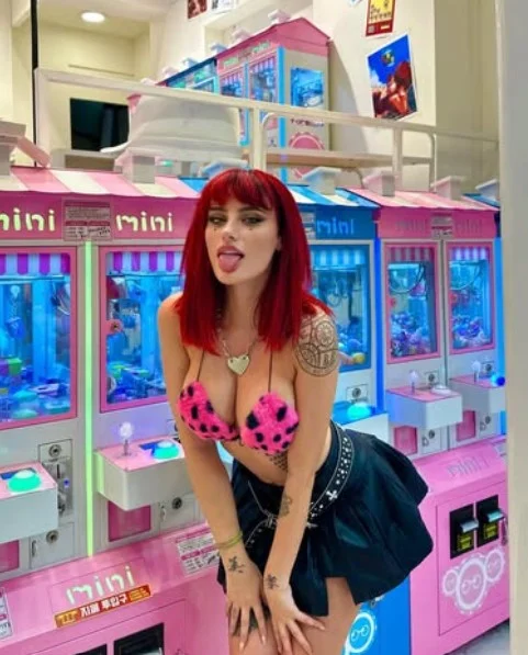 Merisiel Irum @m3risiel foto del modello OnlyFans all'arcade che indossa un reggiseno rosa mostrando il suo décolleté