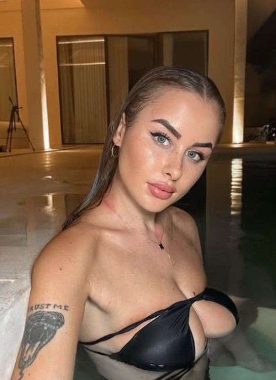 Nanda Alfì @itsnandalfi foto del modello OnlyFans in piscina che mostra la scollatura