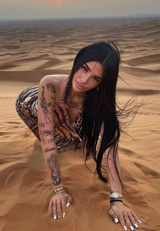 Vittoria Lazzari nel deserto e vestito con un abito marrone.