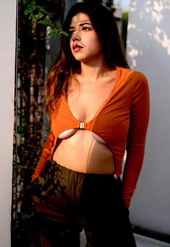 Elisabetta Zaffiro vestita con un sexy top marrone e pantaloni neri