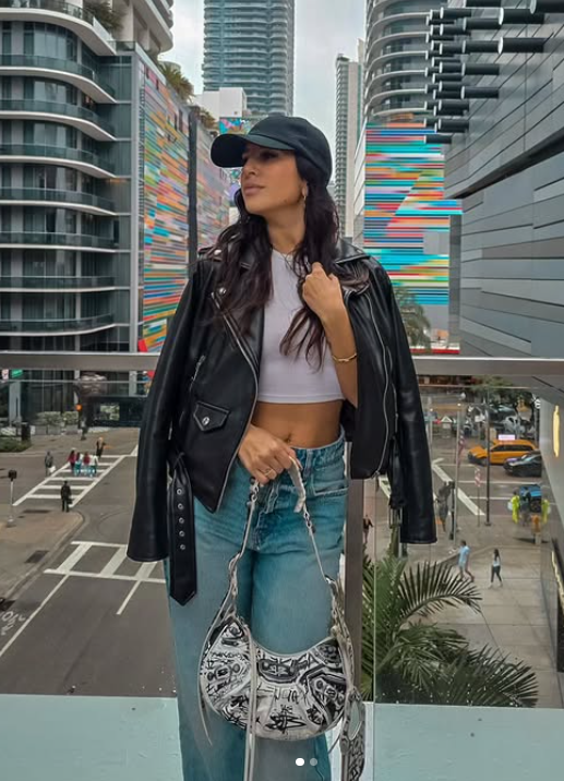 Ilaria Sigaudo vestita con un sexy top corto bianco e pantaloni blu jeans